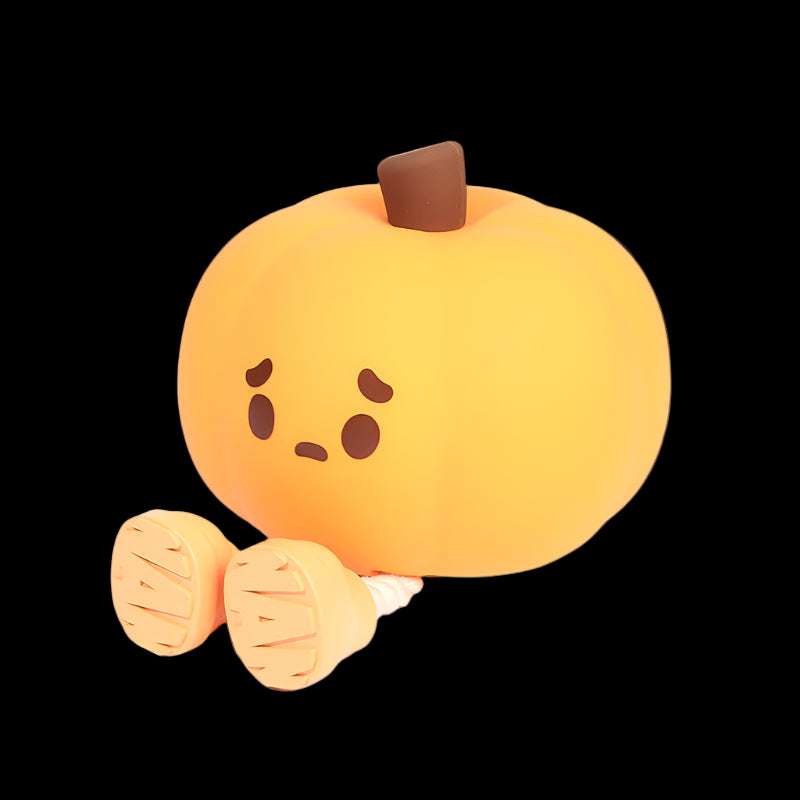 Plush toy shaped like a pumpkin with a sad face on a white background