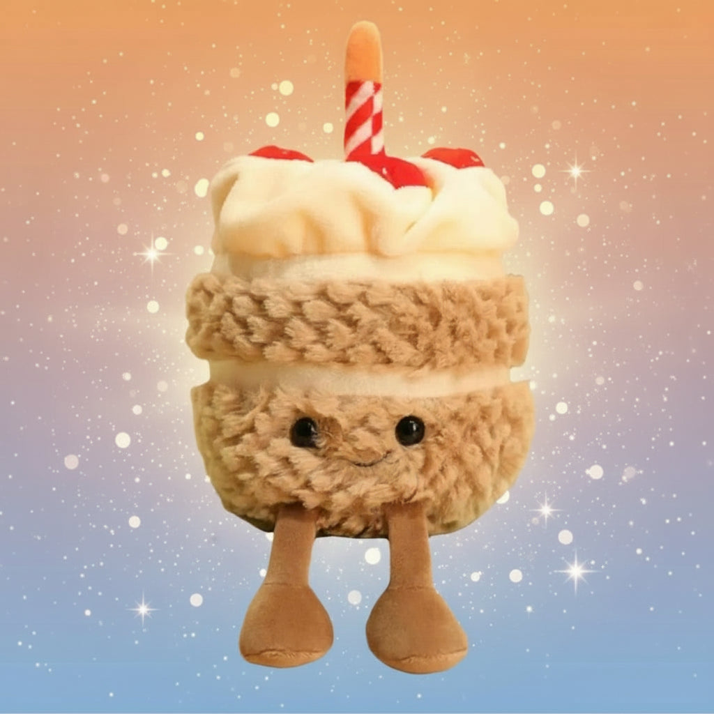 Plush toy resembling a birthday cake with a candle on a book