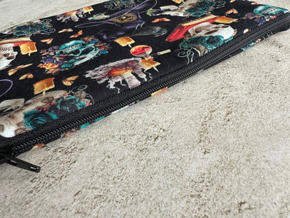 Colorful makeup bag with a witch-themed design on a textured surface