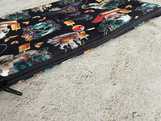 Colorful makeup bag with a witch-themed design on a textured surface