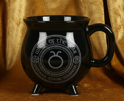 Black mug with a circular design featuring text and symbols on a white background