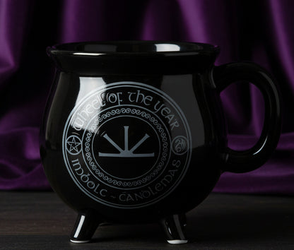 Black mug with a circular design and text on a white background