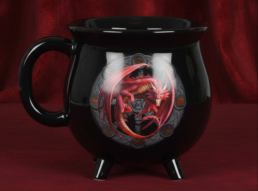 A glossy black cauldron-shaped mug with three small feet and a handle, featuring a red dragon illustration on the front, set against a plain white background.