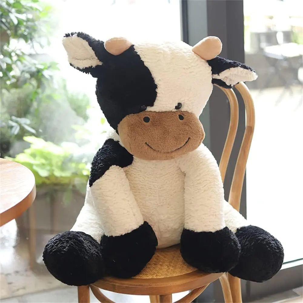 Plush cow toy sitting on a chair with a blurred indoor background