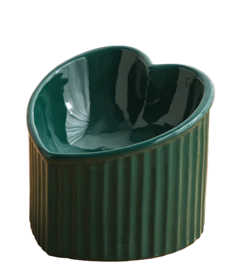 Heart-shaped green ceramic bowl on a wooden surface
