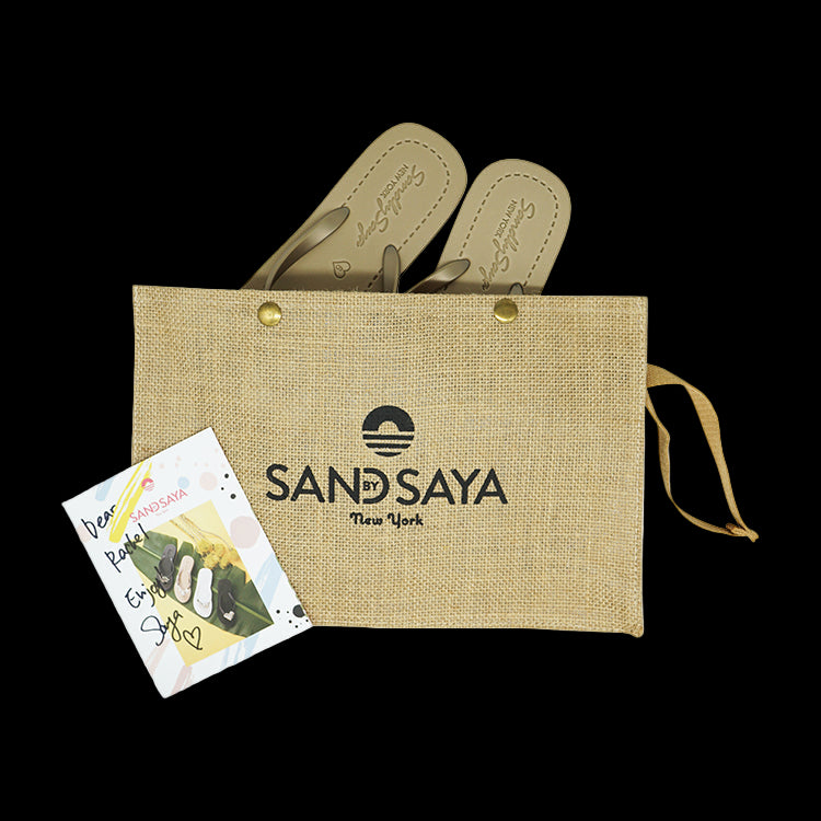 Pair of sandals in a jute bag with 'SANDSAYA' branding on a white background