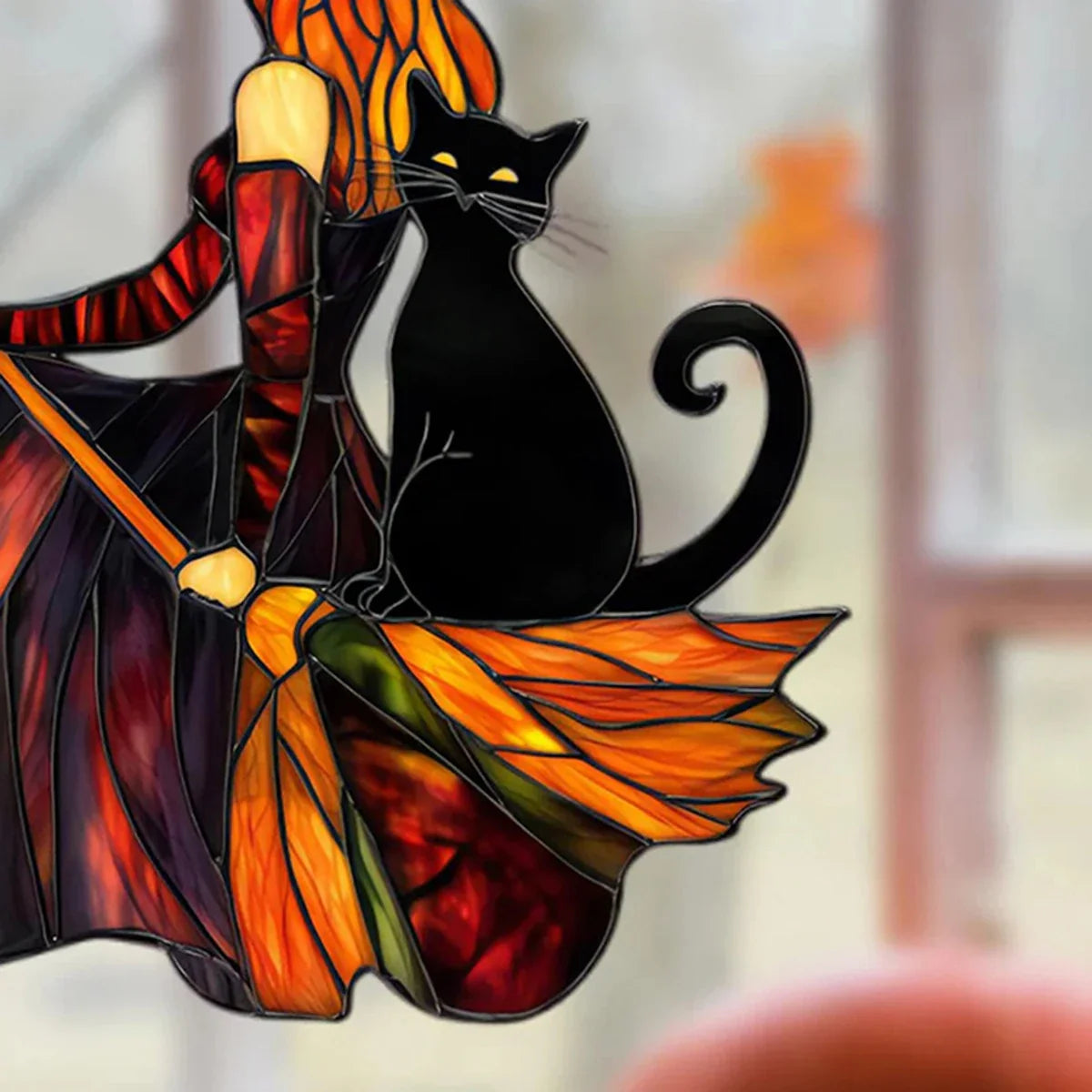 Stained glass panel with a black cat and colorful wings on a blurred background