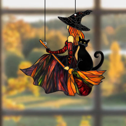Decorative stained glass witch and black cat on a broom hanging against a blurred autumn window background.