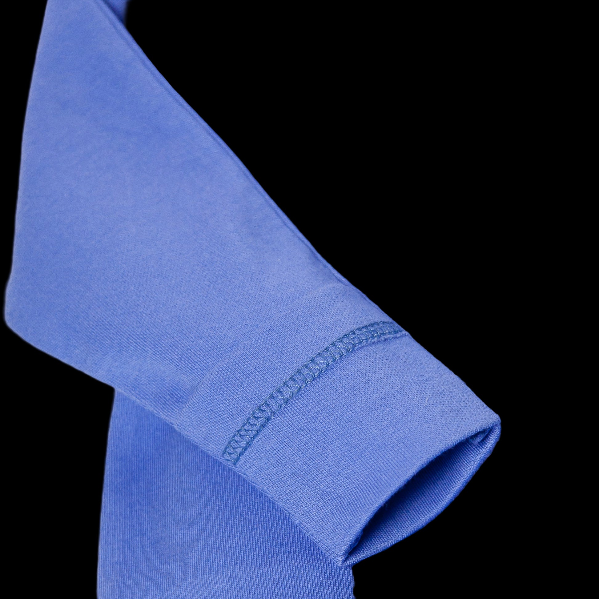 Close-up of a blue shirt with rolled-up sleeve on a light gray background