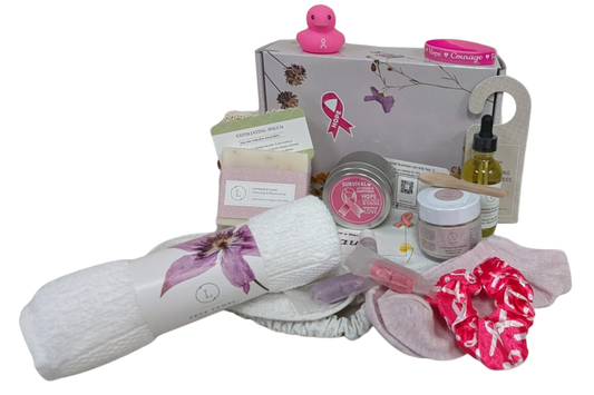 Collection of beauty and self-care products including a bath bomb, soap, and towels on a white background.