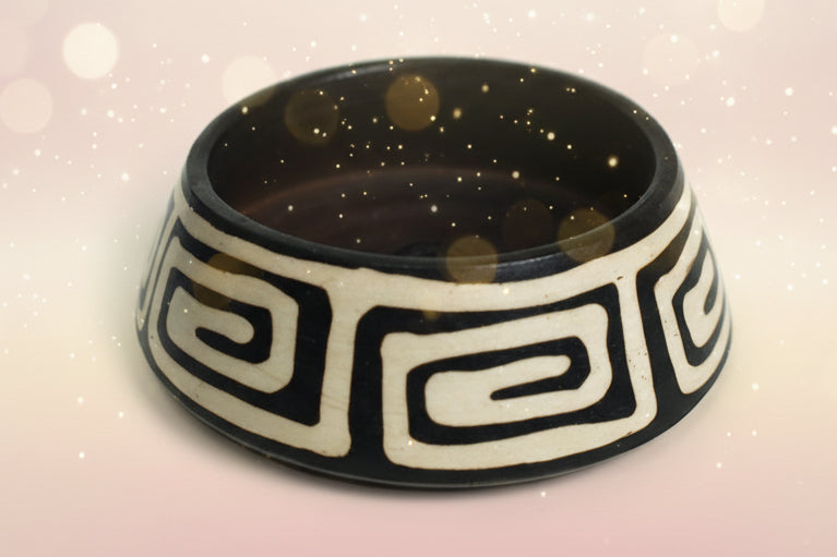 Black and beige ceramic bowl with decorative patterns on a white background
