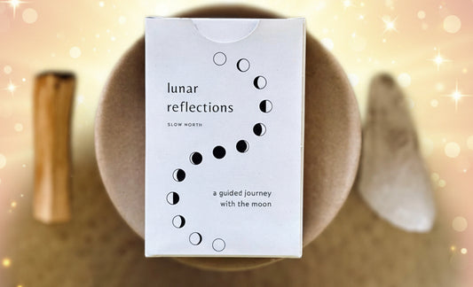 Box labeled 'lunar reflections' on a textured surface with natural elements.