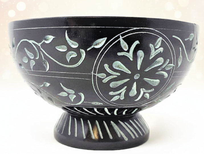 Black ceramic bowl with white floral patterns on a white background