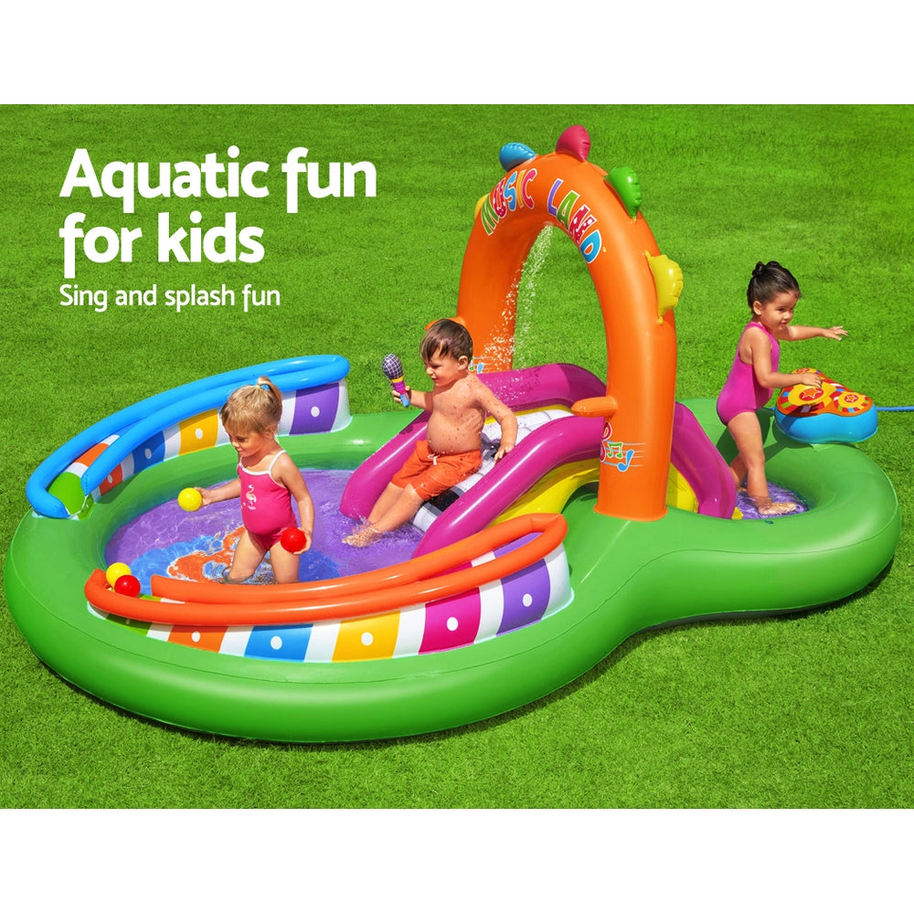 Children playing in a colorful inflatable water park on grass