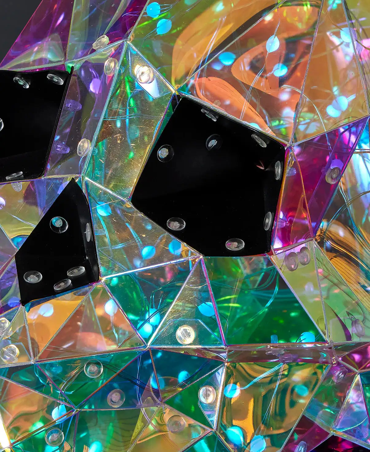 Colorful geometric pattern with transparent triangles and black dice on a reflective surface.