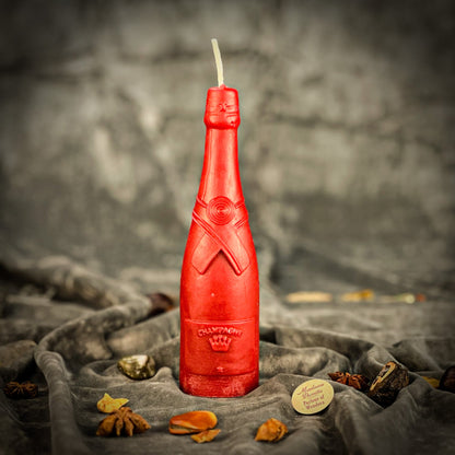 Red bottle-shaped candle with 'Olympea' branding on a textured surface.
