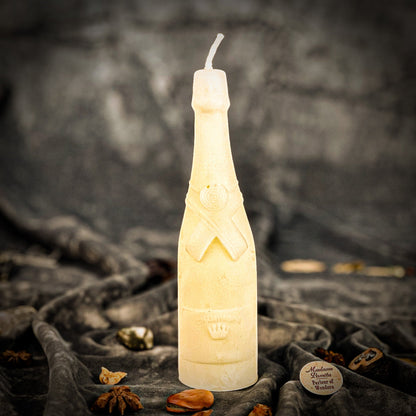 Candle shaped like a bottle on a textured surface with a dark background