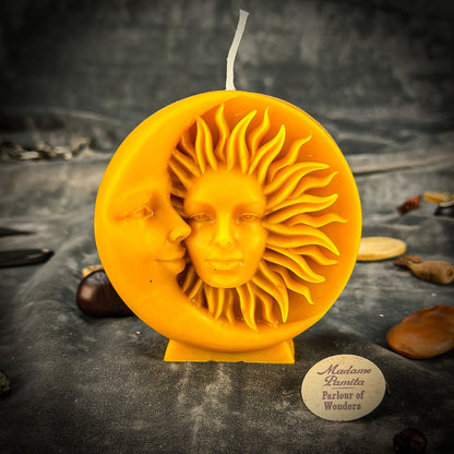 Sun and moon design candle on a dark textured surface with 'Madame Luminia' branding.