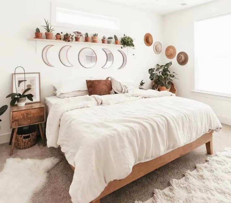 Neatly made bed in a bedroom with decorative elements like plants and wall art.