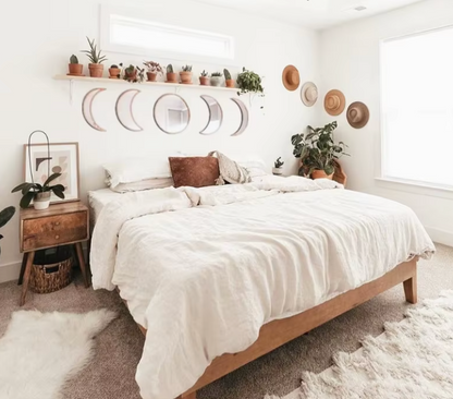 Neatly made bed in a bedroom with decorative elements like plants and wall art.