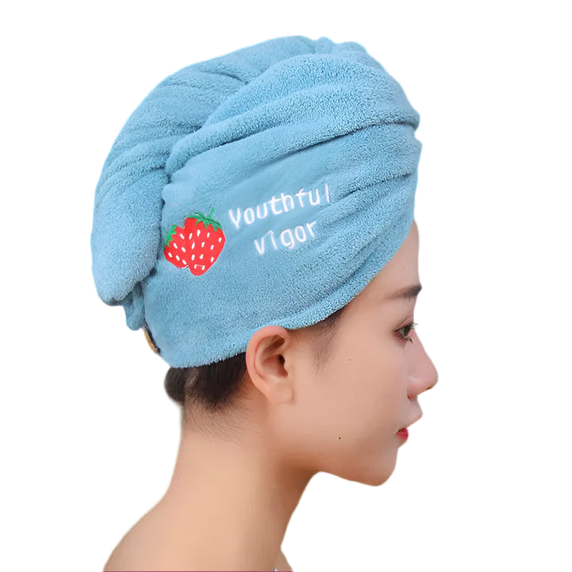 Person wearing a blue towel with 'Youthful vigor' and a strawberry design, against a blurred background.