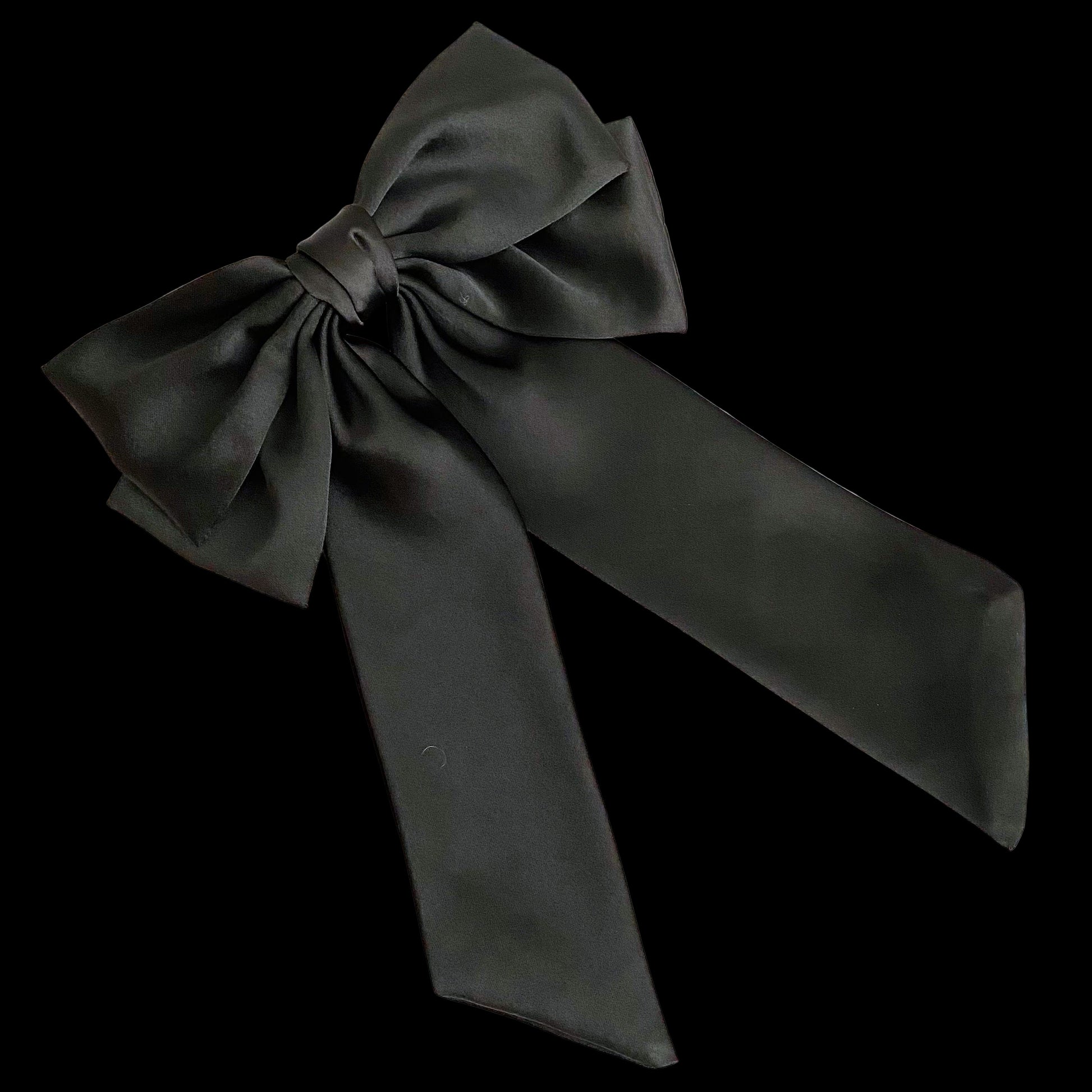 Black satin bow on a light wooden surface