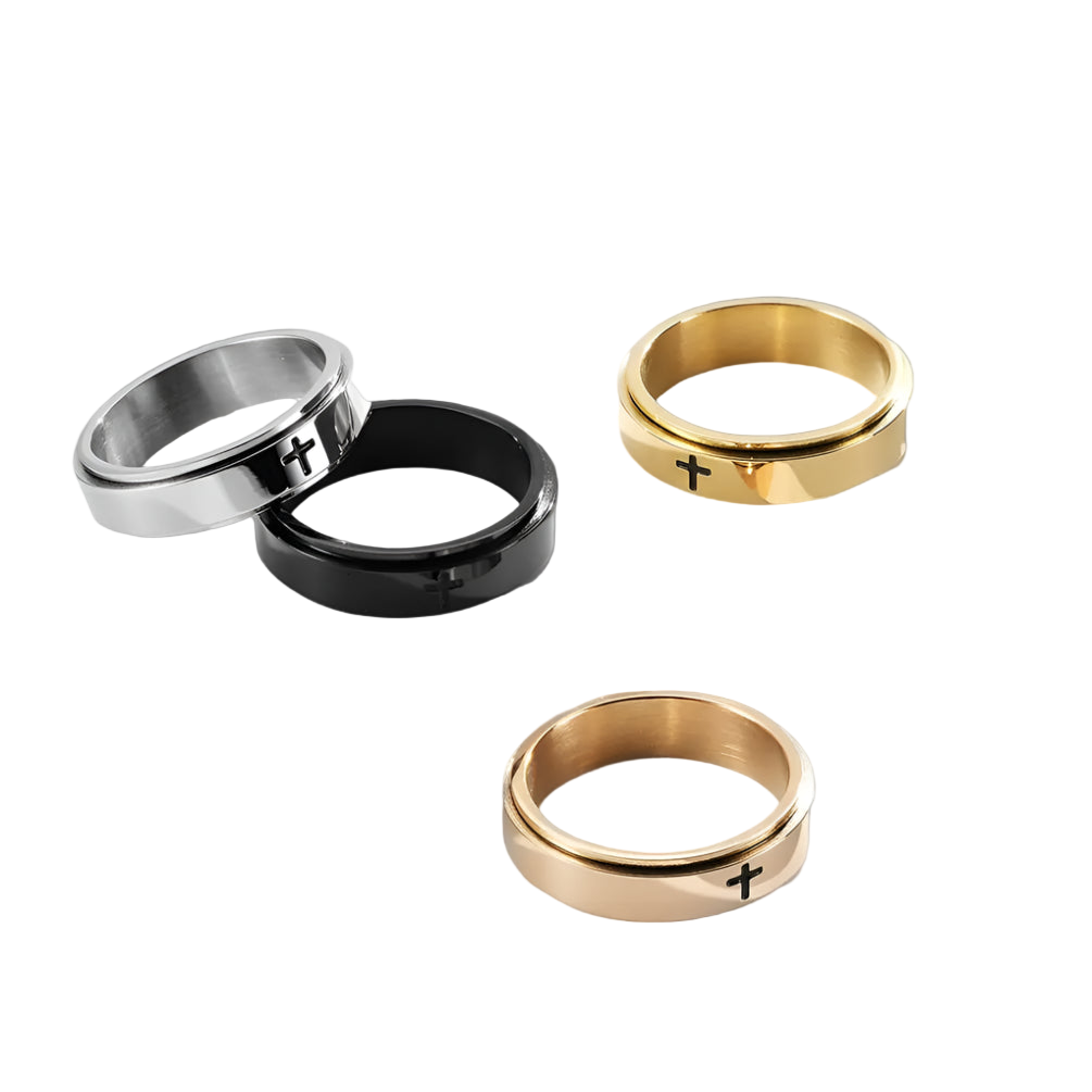 Three rings in gold, black, and silver on a white surface