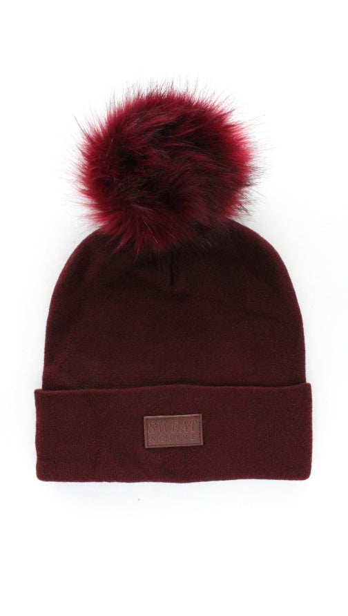 Brown beanie with a red pom-pom on a white background