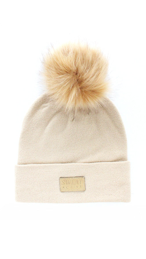 Beige beanie with a fur pom-pom on a white background