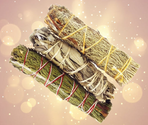 Three bundles of green herbs tied with red, yellow, and white string on a white background