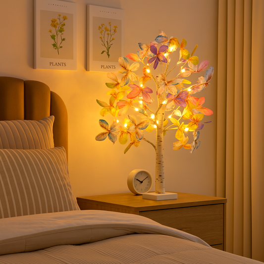 Decorative floral lamp on a bedside table with a bed and headboard in the background