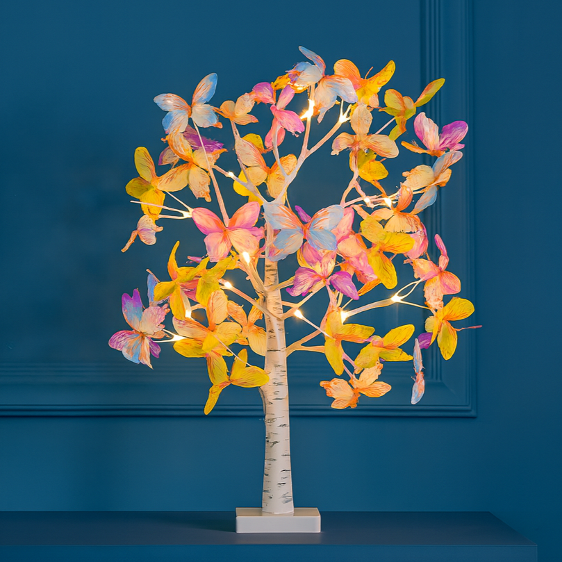 Decorative tree with colorful butterfly lights against a blue wall