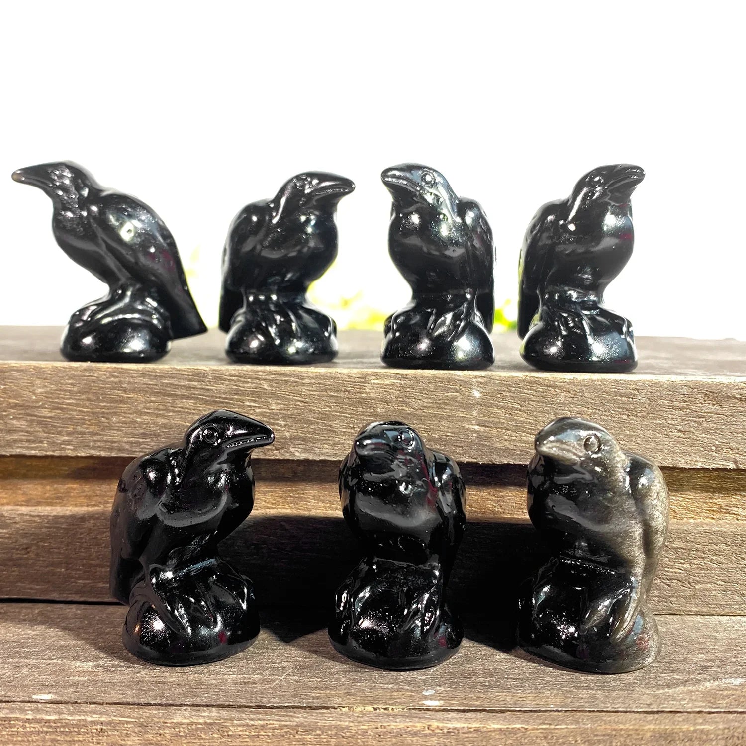 Set of black ceramic bird figurines on a wooden surface
