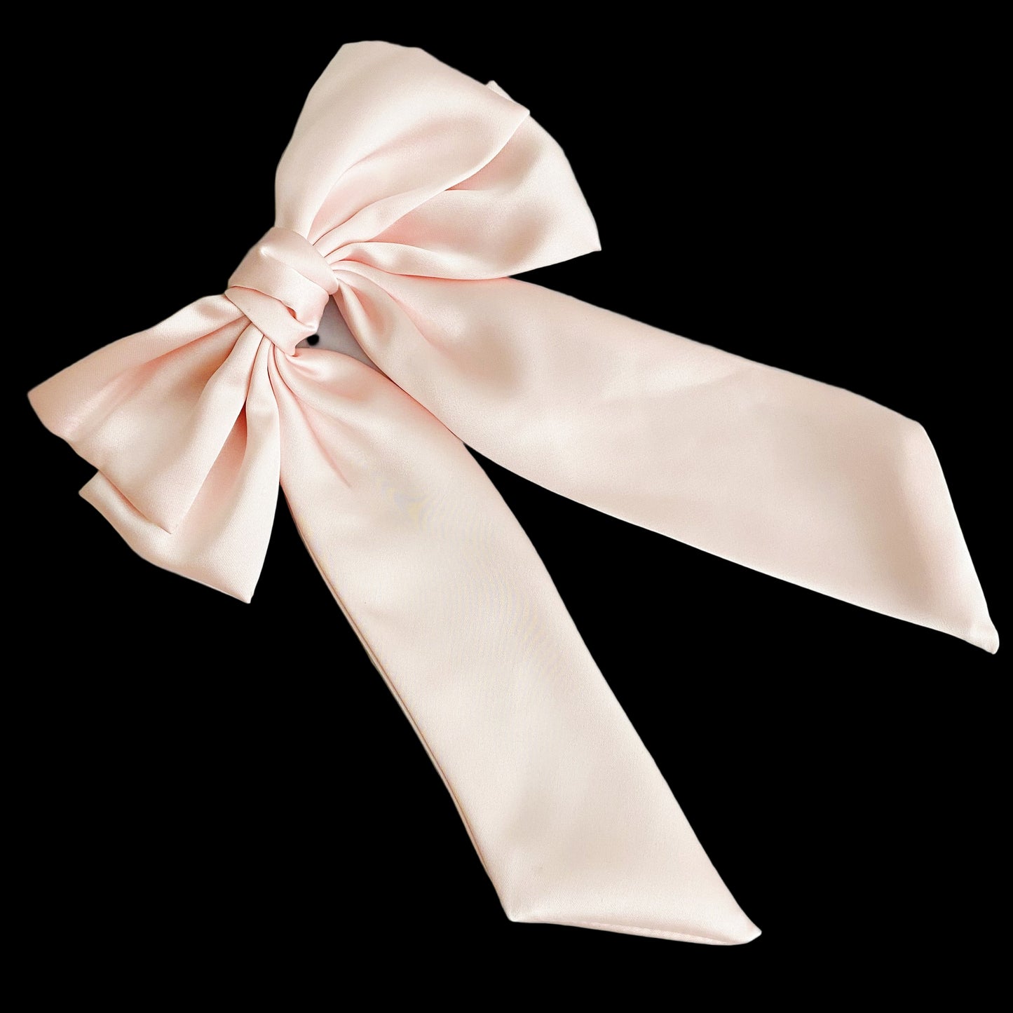 Large pink satin bow on a light blue wooden surface