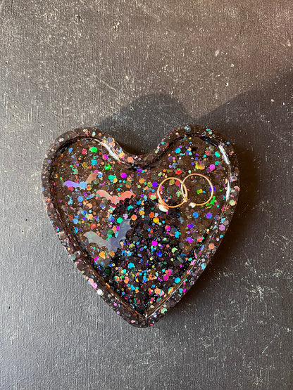 Heart-shaped object with glittery finish on a dark surface