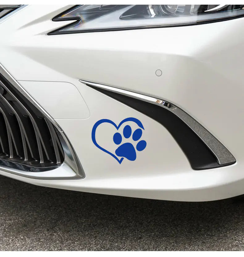 Blue paw print inside a heart shape decal on a white car.