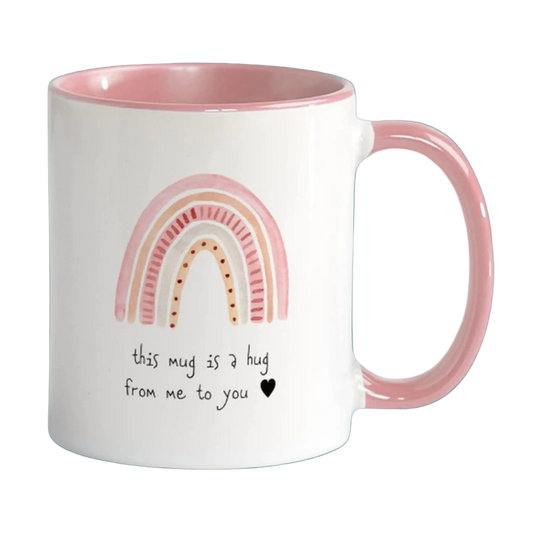 White mug with pink interior and handle, featuring a rainbow design and text on a white background