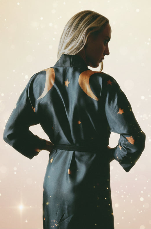 Person wearing a dark blue jumpsuit with star patterns in an indoor setting