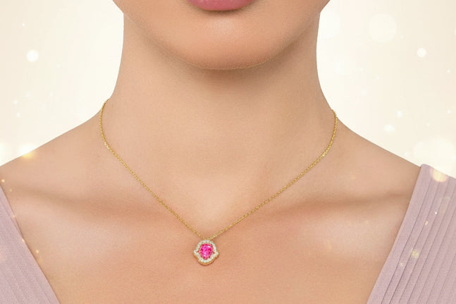 Necklace with a pink gemstone worn by a model on a plain background