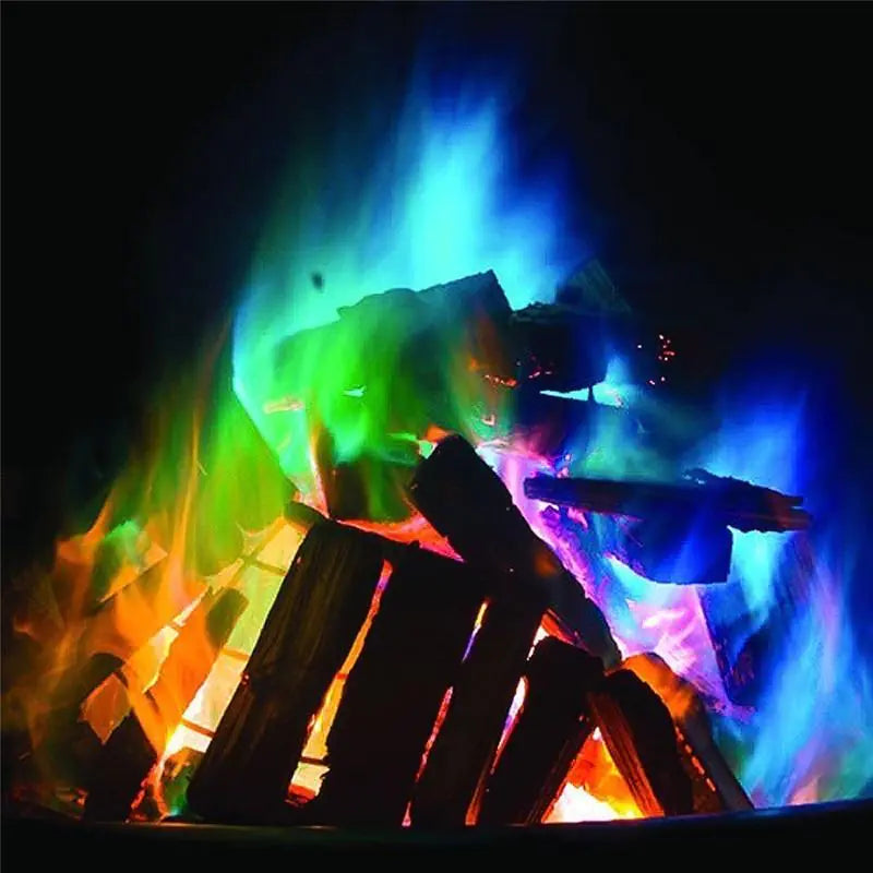 Colorful flames from a fire pit with glowing logs against a dark background