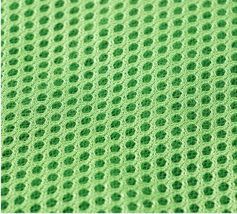 Close-up of green textured fabric with a honeycomb pattern