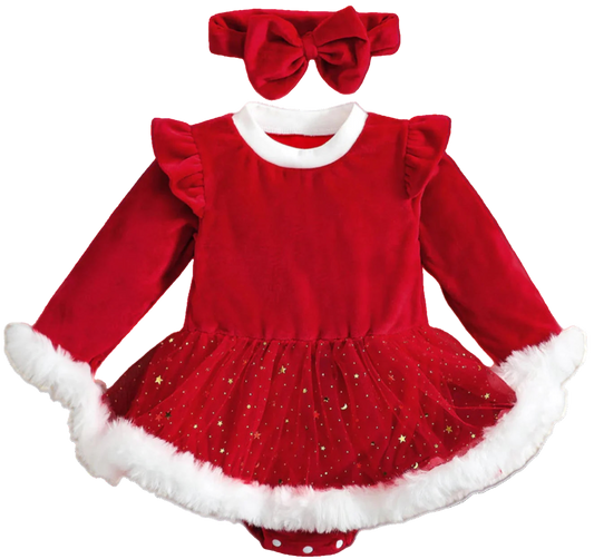 Red Christmas dress with white trim and matching headband on a wooden surface with holiday decorations.