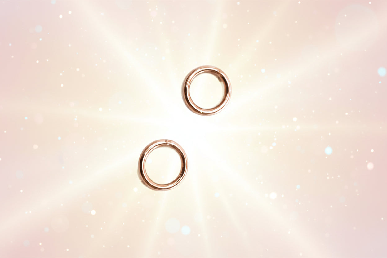 Pair of rose gold hoop earrings on a white background