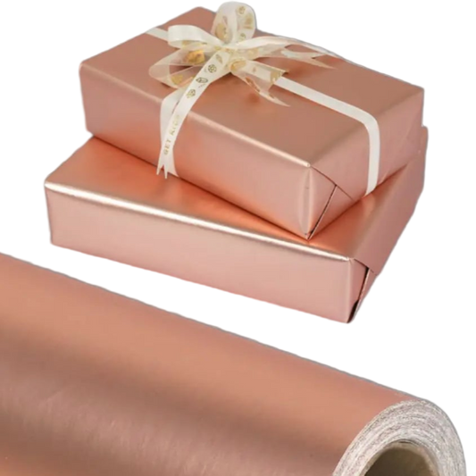 Roll of rose gold gift wrap with two wrapped gifts on a white background
