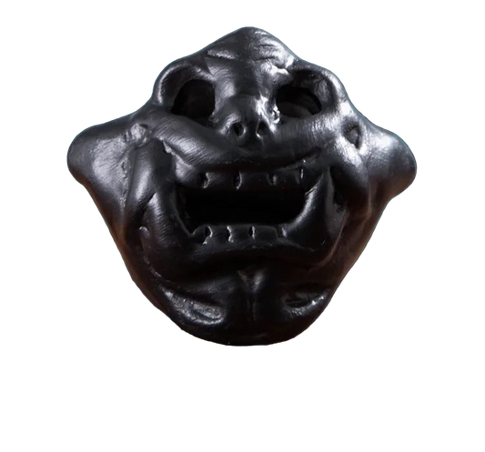 Stress relief toy with a dark, textured surface on a decorative background.