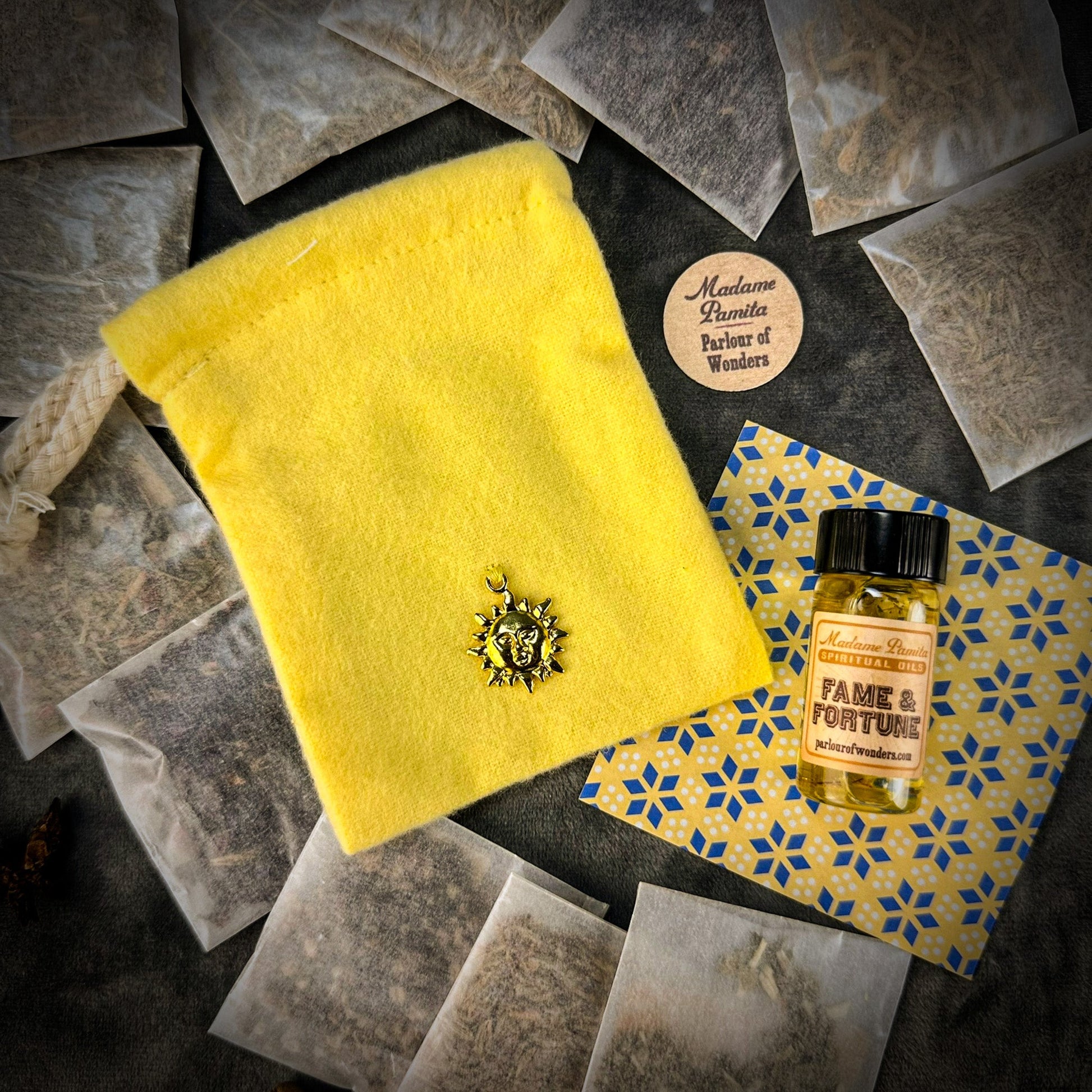 Yellow cloth with a lion emblem, tea bags, and a bottle labeled 'Fame & Fortune' on a patterned surface.