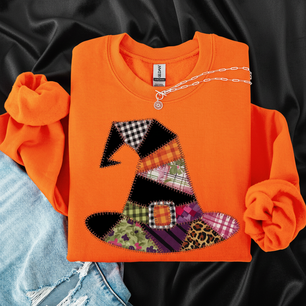 Orange sweatshirt with a colorful patchwork witch hat design on a white background