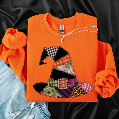 Orange sweatshirt with a colorful patchwork witch hat design on a white background