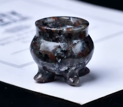 Small brown and black ceramic pot on a white surface