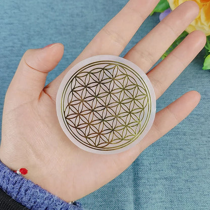 Hand holding a circular sticker with a geometric design on a blue background